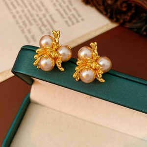 Macro shot of French vintage flower earrings with pearls on a green jewelry box