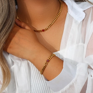 Detail of 18K gold-plated Cuban link necklace and bracelet set with red zircon