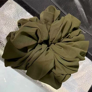 Detailed view of an olive green oversized chiffon scrunchie with soft pleated texture