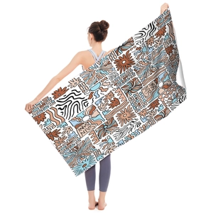 Detail of a large microfiber beach towel featuring SUN SHINE graffiti held by a model