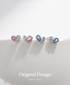 Detail of S925 silver heart studs with pink and blue gemstones on minimalist display
