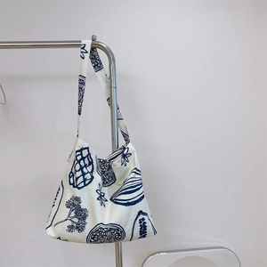 Détail de la bandoulière large et imprimé botanique bleu sur sac en toile de coton