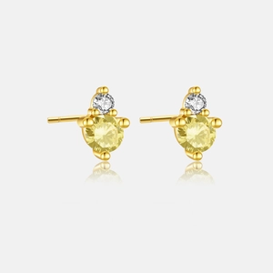 Macro detail of gold plated S925 silver stud earrings with yellow and clear crystals