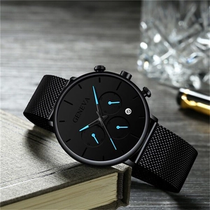 Macro shot of black mesh strap watch featuring blue hands and circular date window