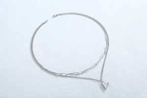 Détail du collier double couche en acier inoxydable avec pendentif cœur argenté