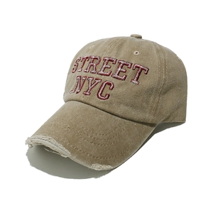 Dettaglio visiera usurata e ricamo STREET NYC rosso su cappello in cotone lavato
