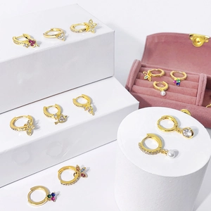 Collection of gold-plated hoop earrings with colorful zircon, pearls, and charms
