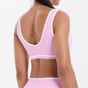 Détail du dos nu en U et de la bordure contrastée blanche sur une brassière de sport rose