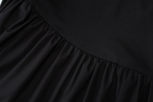 Detailaufnahme der schwarzen Kleidstoff-Textur mit elegantem Fall und gefalteten Details