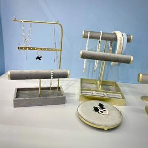 Présentoir à bijoux élégant en métal doré et velours gris pour colliers et bagues