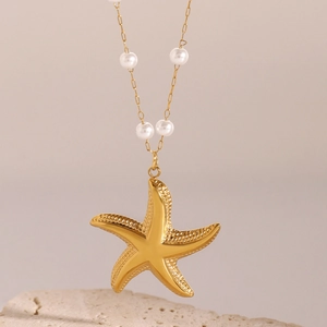 Collier étoile de mer en acier inoxydable doré avec perles élégantes sur un socle en pierre