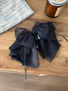 Detail of layered black organza bow hair claw clip with long tassels and silver beads