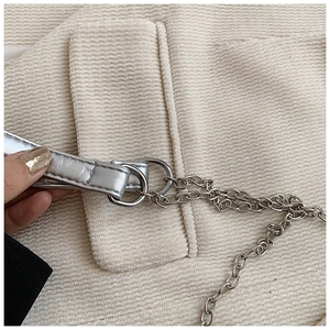 Nahaufnahme der cremeweißen Cord-Textur mit silberner Metallkette und Schultergurt-Detail