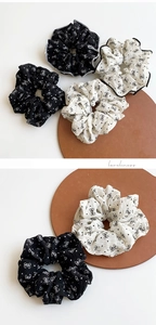 Close-up of black and white polka dot scrunchies with bow patterns and crepe fabric texture