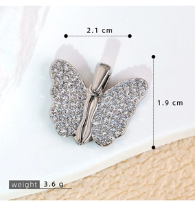 Detailed macro view showing the 2.1cm butterfly pendant dimensions and zircon stones
