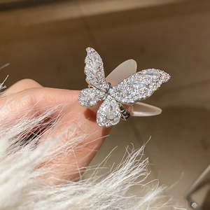 Macro shot of silver butterfly ring with micro-pave white zircon crystals on fingers