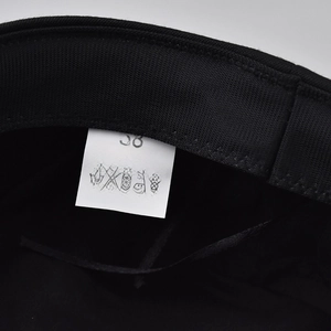 Internal detail of black beret showing 58 size label with cotton and polyester blend info