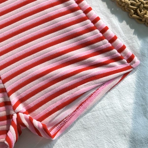 Macro shot of red and pink striped velvet texture and detailed stitching on a bikini