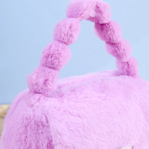 Detail of purple plush vanity bag featuring unique spherical beaded handle and soft texture