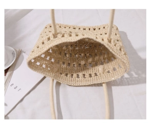 Top view of hollow-out woven straw tote bag showing spacious beige interior detail