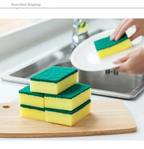 Close-up of double-sided kitchen sponges with green scouring pad and yellow sponge on wood