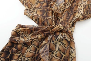 Detail of snake skin print midi dress with ruffled neckline and waist tie fastener