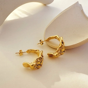 Detail of 18k gold plated C-shape earrings featuring liquid lava texture on art stone