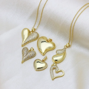Polished gold plated heart necklaces with sparkling zircons on elegant satin fabric