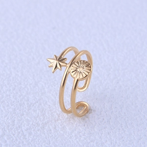 Detail of adjustable gold double-layer steel ring with star and sunburst motifs