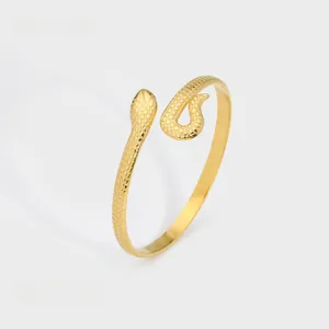 Detail view of gold snake-shaped open bangle with textured scales and 0.46cm width