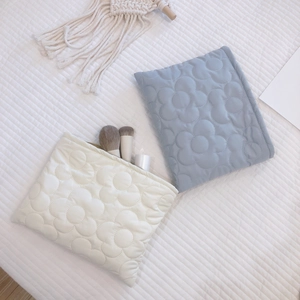 Quilted floral puffer cosmetic bags in cream and light blue with soft embroidery details