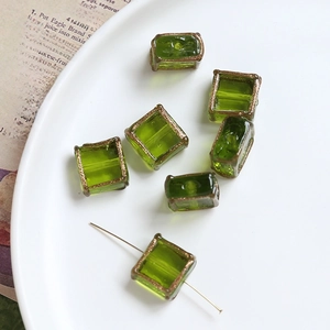 Detail of vintage square glass beads in grass green with gold edges for DIY jewelry making