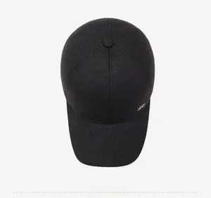 Top view of a thick black wool baseball cap for men featuring a metallic side logo detail