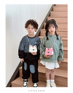 Close-up of white and pink bear shaped crossbody bags worn by children on stairs