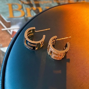 Gold-plated C-shaped earrings with Greek key patterns, black enamel, and white zircon