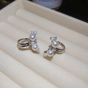 Macro shot of silver pearl clip earrings with sparkling zircons on velvet jewelry box