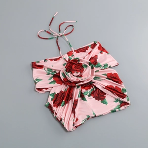 Détail du haut dos nu rose avec imprimé roses et fleur 3D en tissu satiné brillant