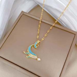 Detail view of dolphin tail pendant with blue enamel and pearl on gold chain necklace
