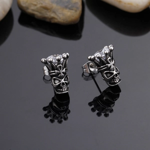 Macro shot of punk skull crown stud earrings with sparkling cubic zirconia inlay