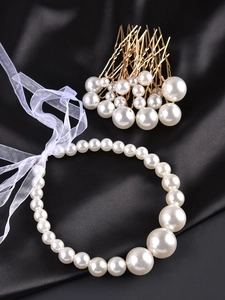 Detail of white pearls hair accessory with golden clips on elegant black silk background