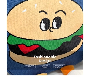 Detailed close-up of cartoon burger embroidery on durable blue canvas crossbody bag