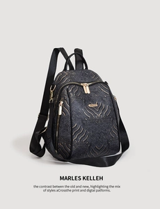 Detail of black backpack featuring a 3D wave texture fabric and gold metal zippers