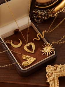 Detailed view of vintage 18k gold plated moon and heart pendants in a velvet jewelry box