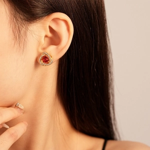 Detail of vintage flower stud earring with red gemstone and sparkling crystal spirals