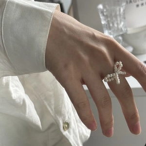 Detail view of a handcrafted pearl bow ring featuring elegant white beaded texture