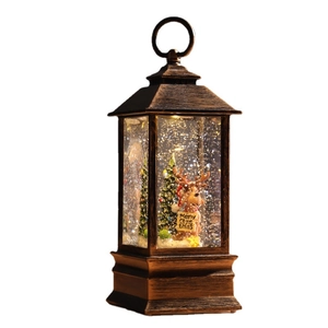 Bronze Christmas water lantern with deer and tree featuring glittering snow and warm LED light