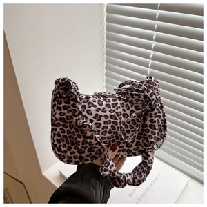 Detail of leopard print tote bag with stylish ruffled strap and textured fabric surface