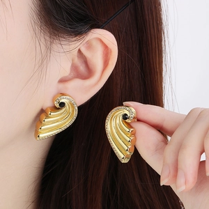 Detailed shot of golden wing stud earrings with black stone and sparkling rhinestones