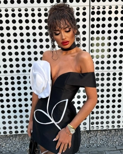 Détail d'une robe bustier noire avec une grande fleur blanche en 3D et broderies perlées