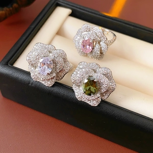 Detailed close-up of zircon flower rings with pink, lilac and olive green oval crystals